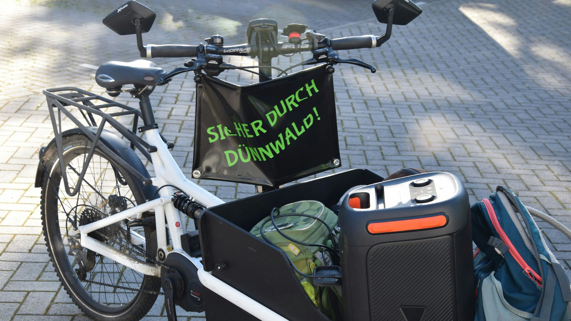 „Sicher durch Dünnwald“ steht am Lastenfahrrad von Stefan Kossmann, der den Fahrradbus anführt.
