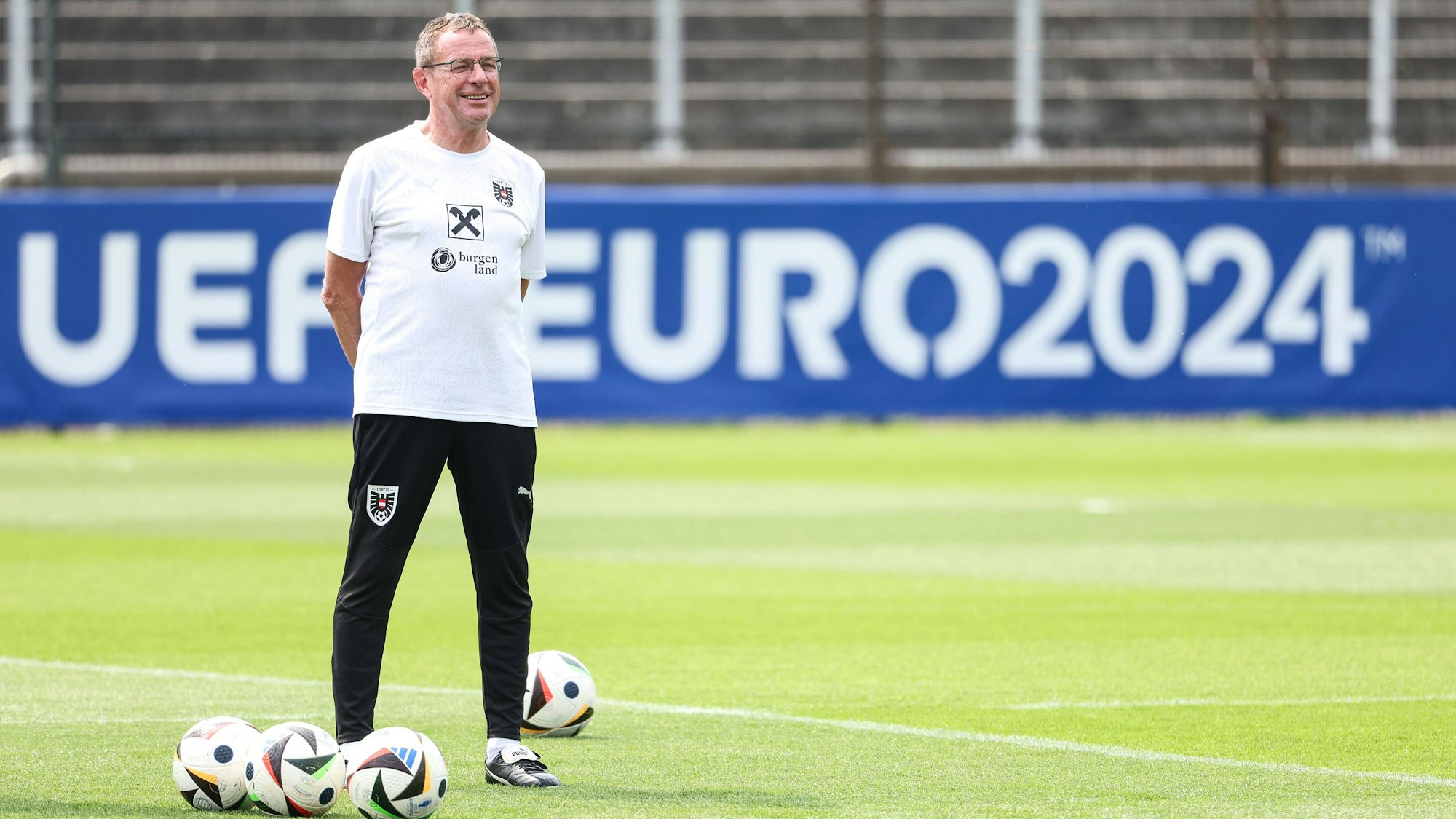 Ralf Rangnick steht in Trainingskleidung auf einem Spielfeld.