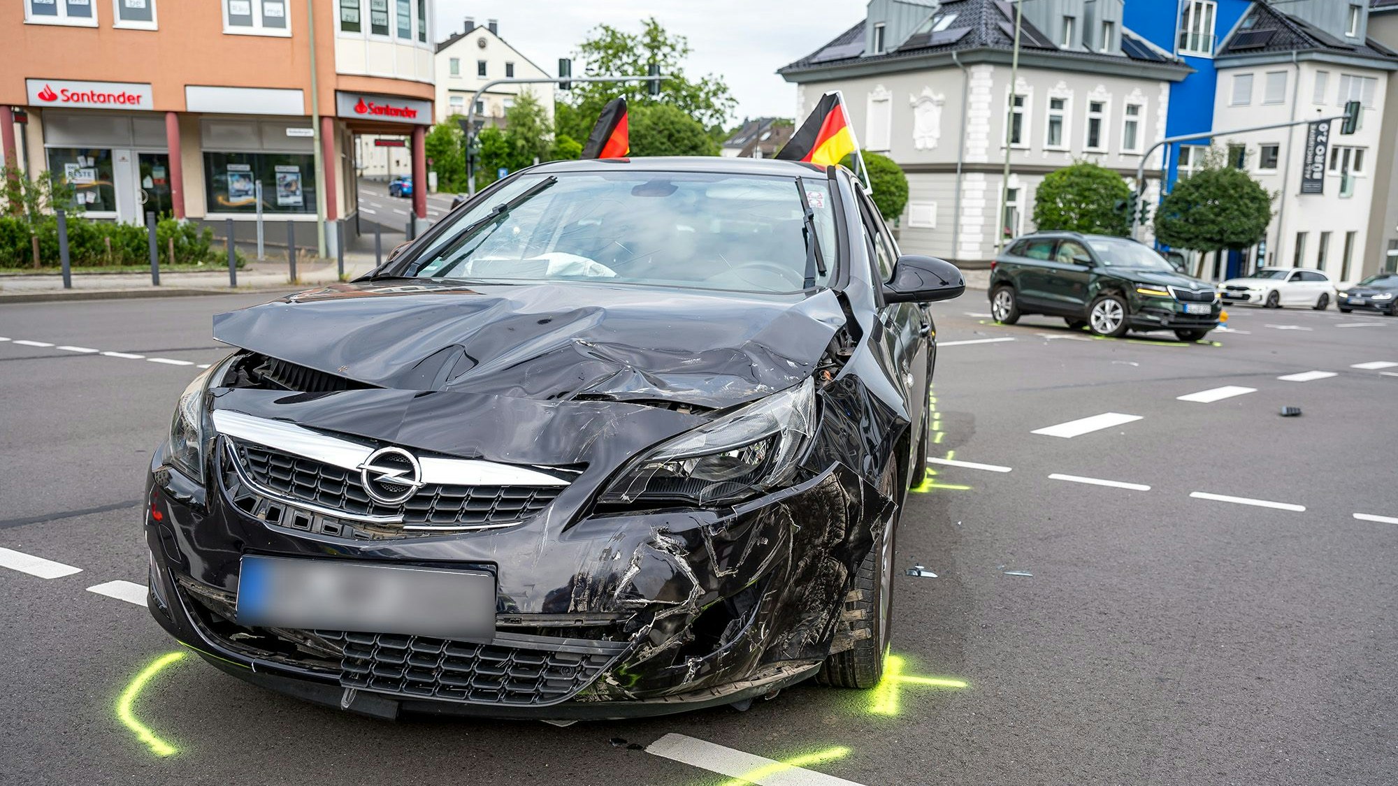 Ein zerbeultes Auto auf einer Kreuzung.
