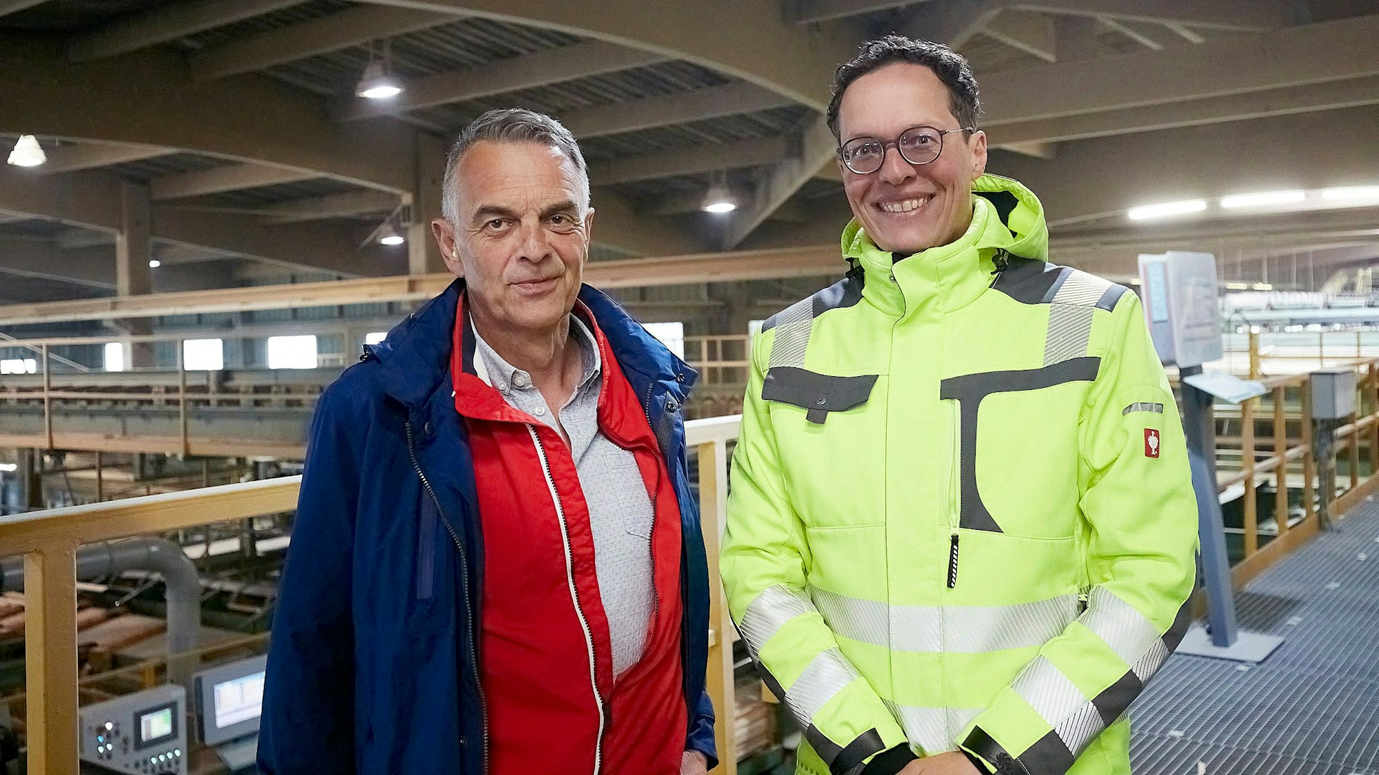 Bürgermeister Rudolf Westerburg (l.) und Geschäftsführer Thomas Perings stehen in einer Halle der Firma Hilo.
