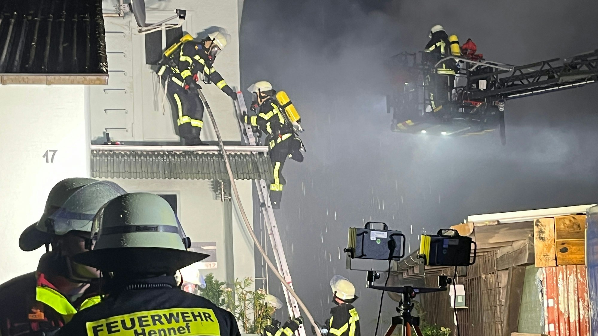 Über eine Steckleiter stiegen Feuerwehrleute auf ein Vordach, um in das Obergeschoss zu gelangen.