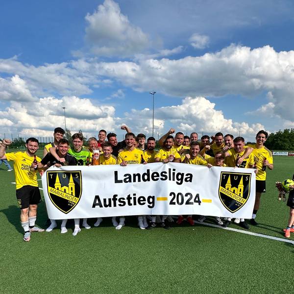 Das Team feiert mit einem Banner den Aufstieg