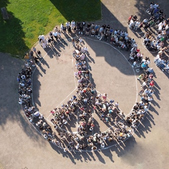 Die Luftaufnahme zeigt Schüler des Johannes-Sturmius-Gymnasiums, die sich zu einem Peace-Zeichen formiert haben.