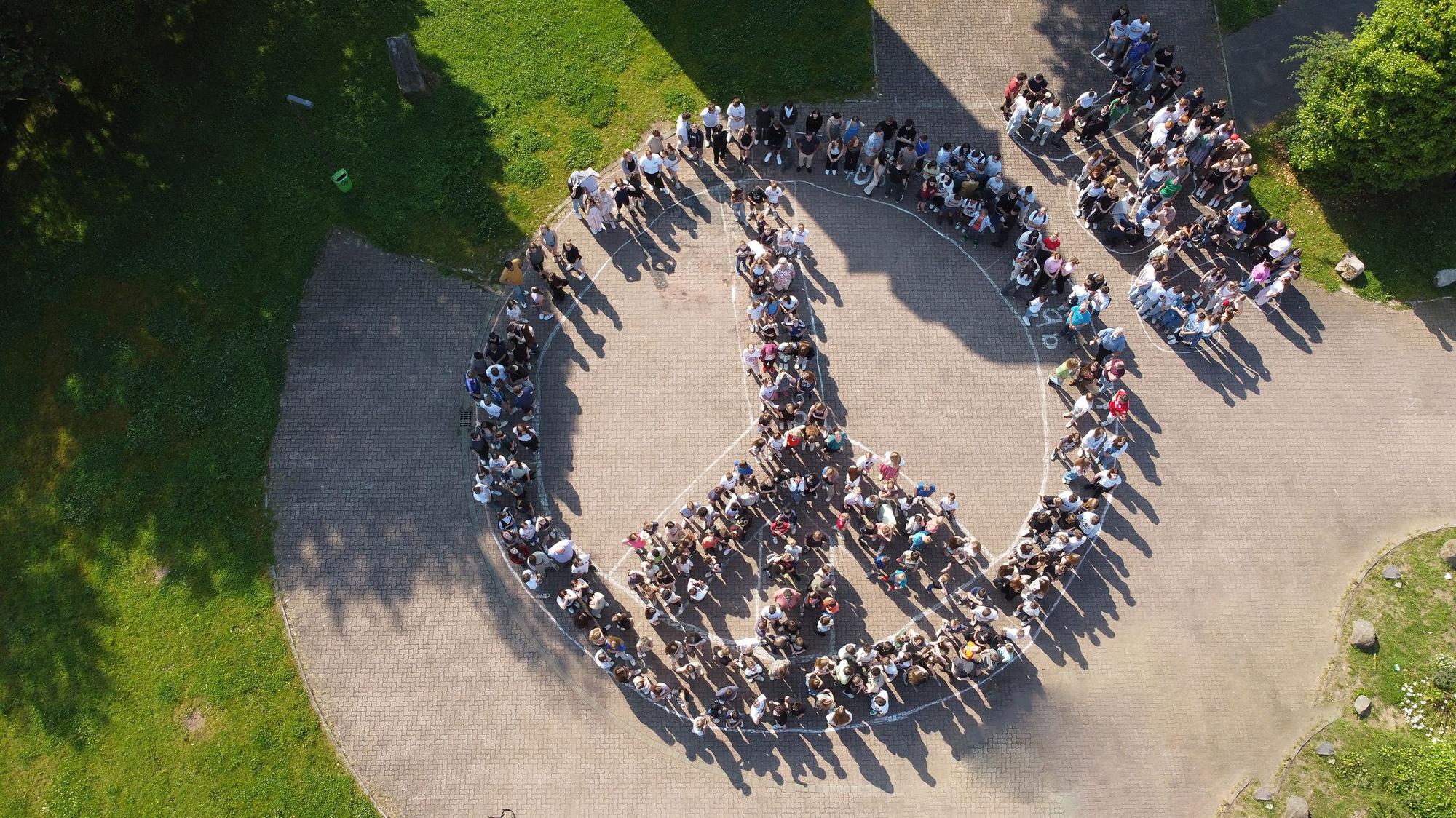 Die Luftaufnahme zeigt Schüler des Johannes-Sturmius-Gymnasiums, die sich zu einem Peace-Zeichen formiert haben.