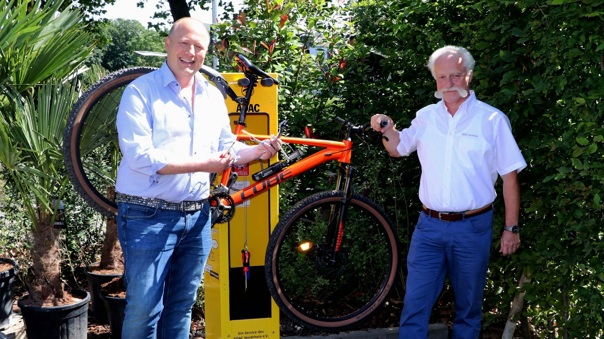 Auf dem Bild ist die neue Radstation mit zwei Männern zu sehen.