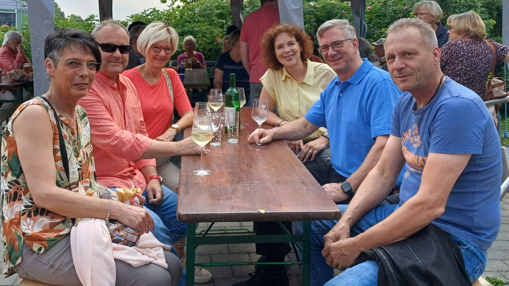 Drei Ehepaare aus Hilgen auf Bierbänken beim Brunnenfest