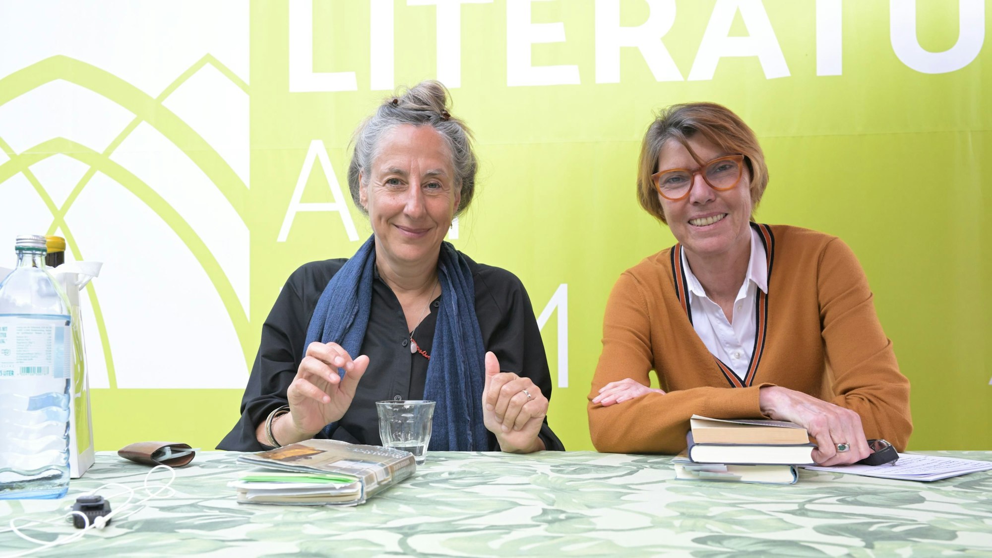 Zwei Frauen auf der Bühne, dahinter ein Plakat mit der Aufschrift: Literatur am Dom.