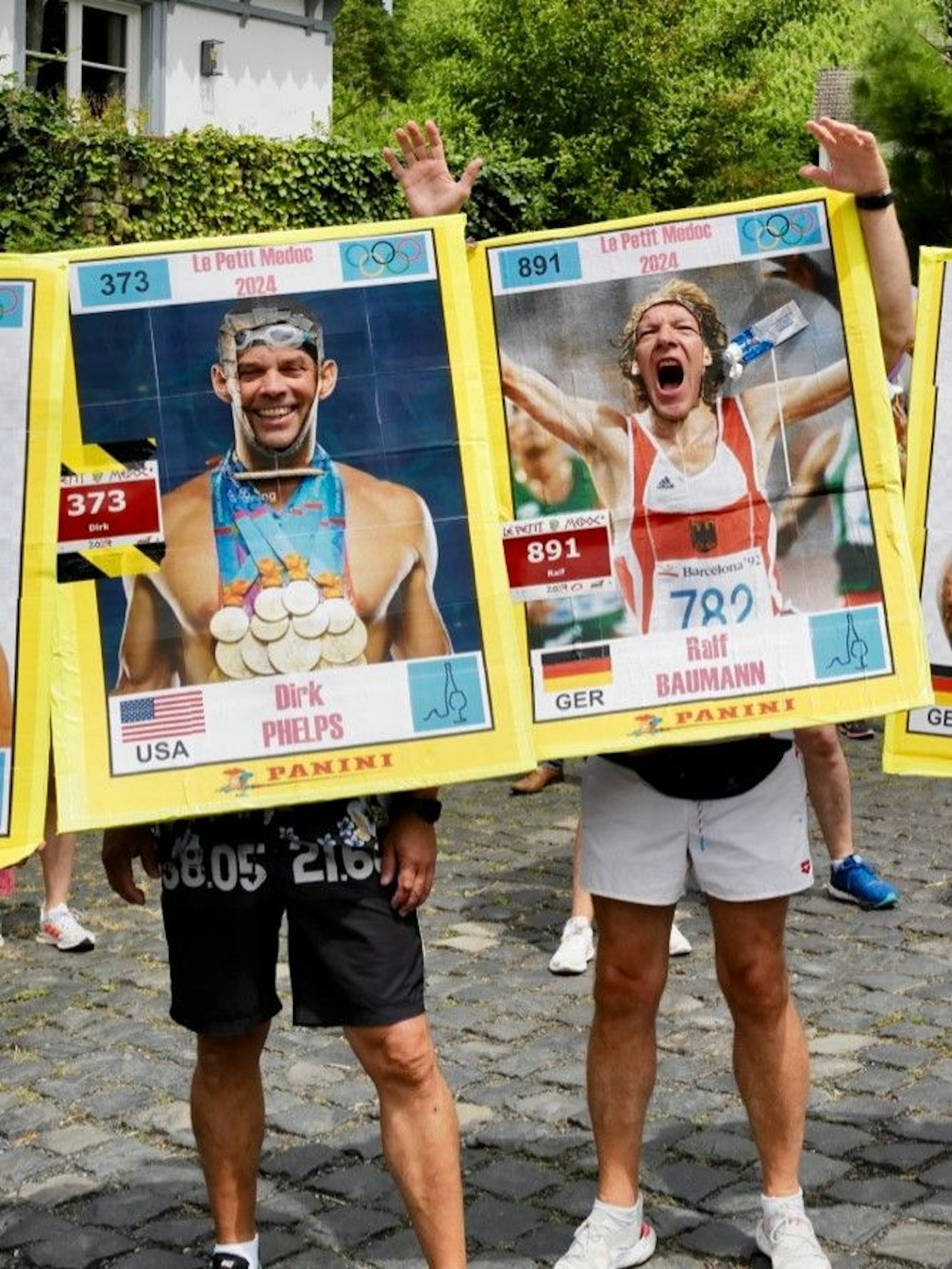 Eigene Vornamen und große Originale trugen die beiden Läufer auf Pappschildern mit, in die sie Löcher für die eigenen Gesichter geschnitten hatten.