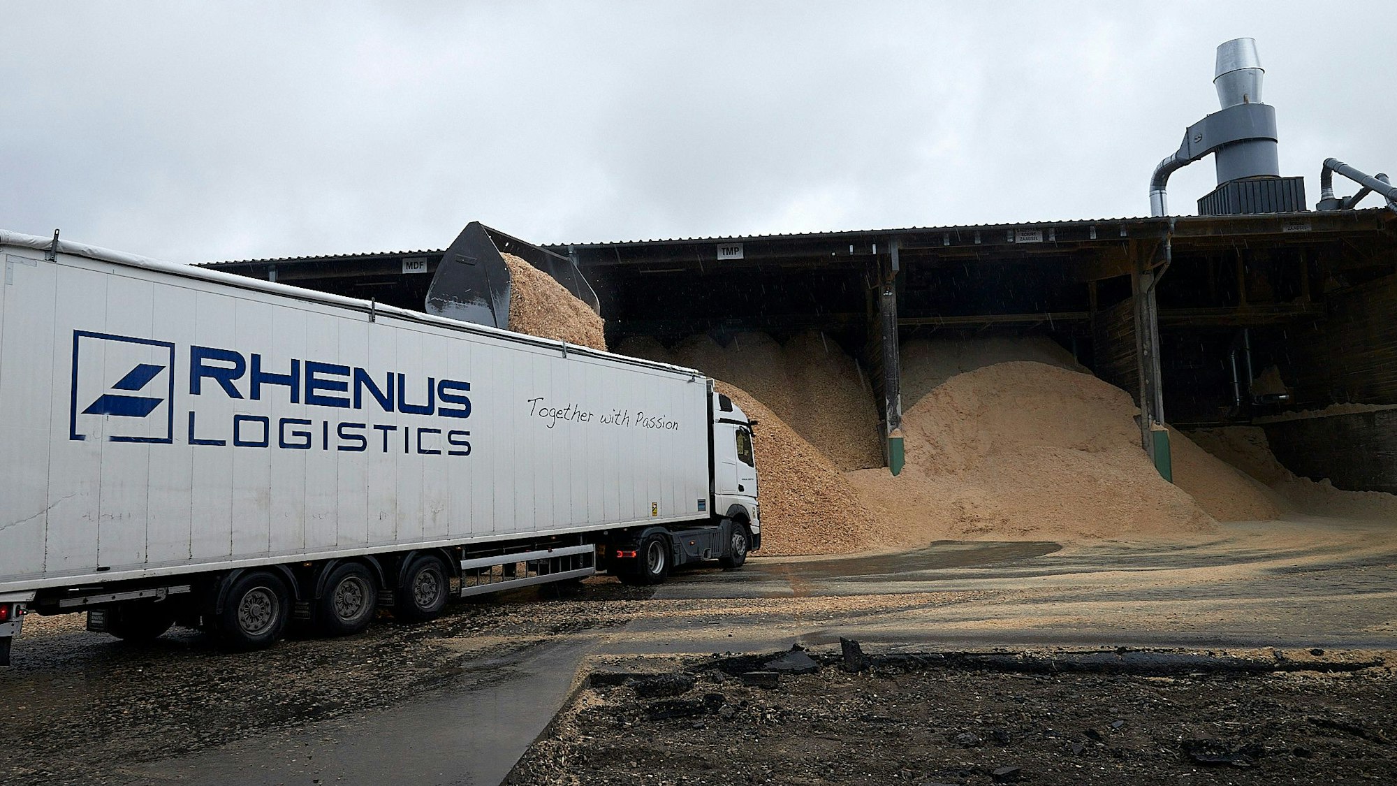 Ein Sattelzug der Firma Rhenus parkt im Sägewerk in Losheim vor einem Spanlager.