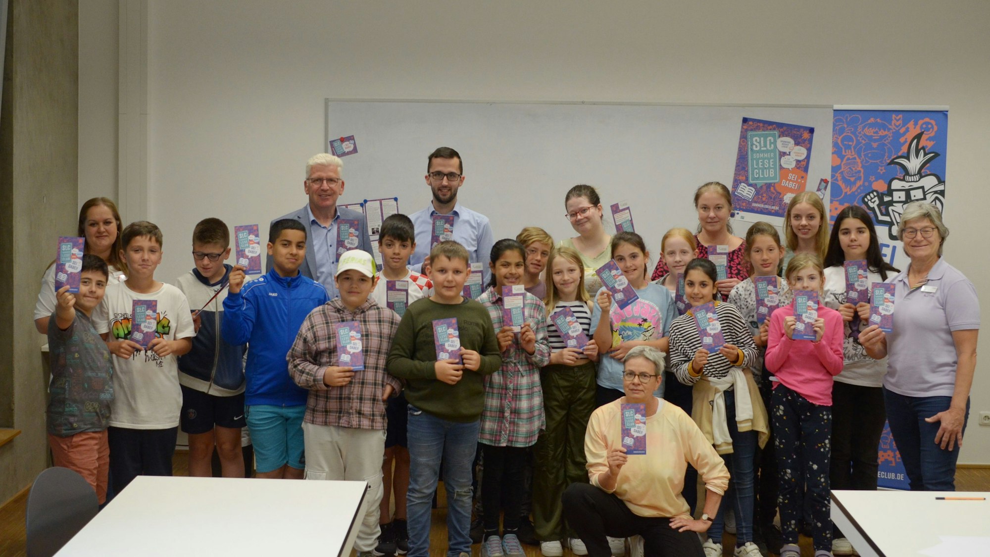 Kinder und Erwachsene haben sich zu einem Gruppenbild aufgestellt.