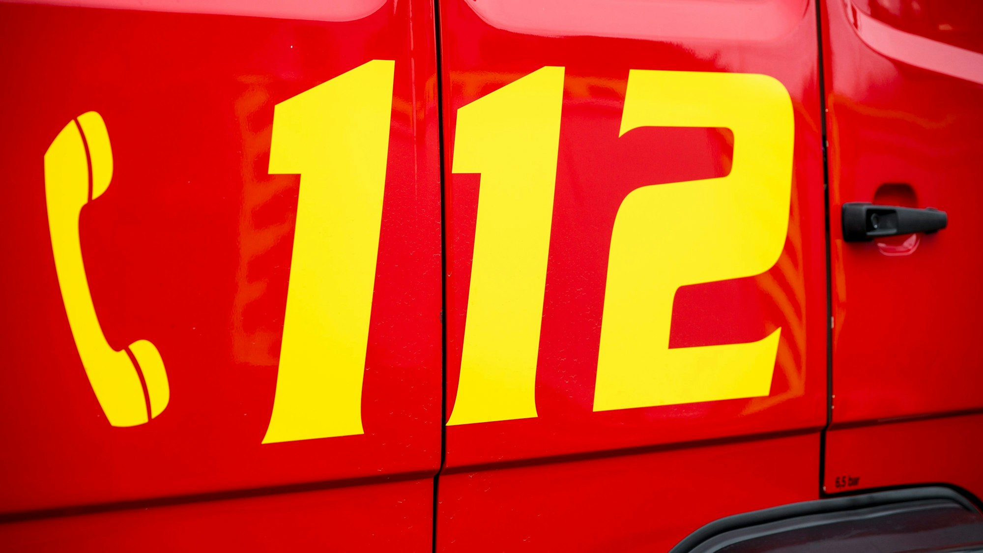 Der Notruf 112 ist auf einem Einsatzwagen der Feuerwehr zu sehen.