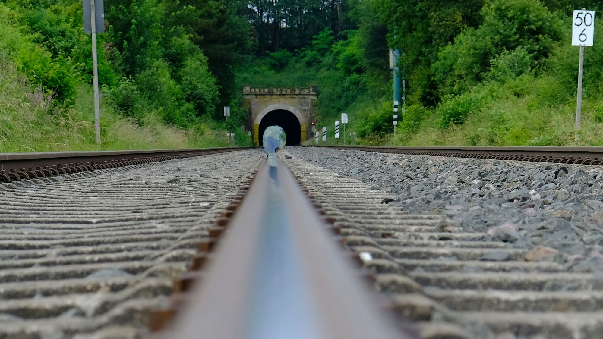 Blick aus Richtung Scheven zum Kaller Tunnel. Im Vordergrund sind die Gleise der Eifelstrecke zu sehen.