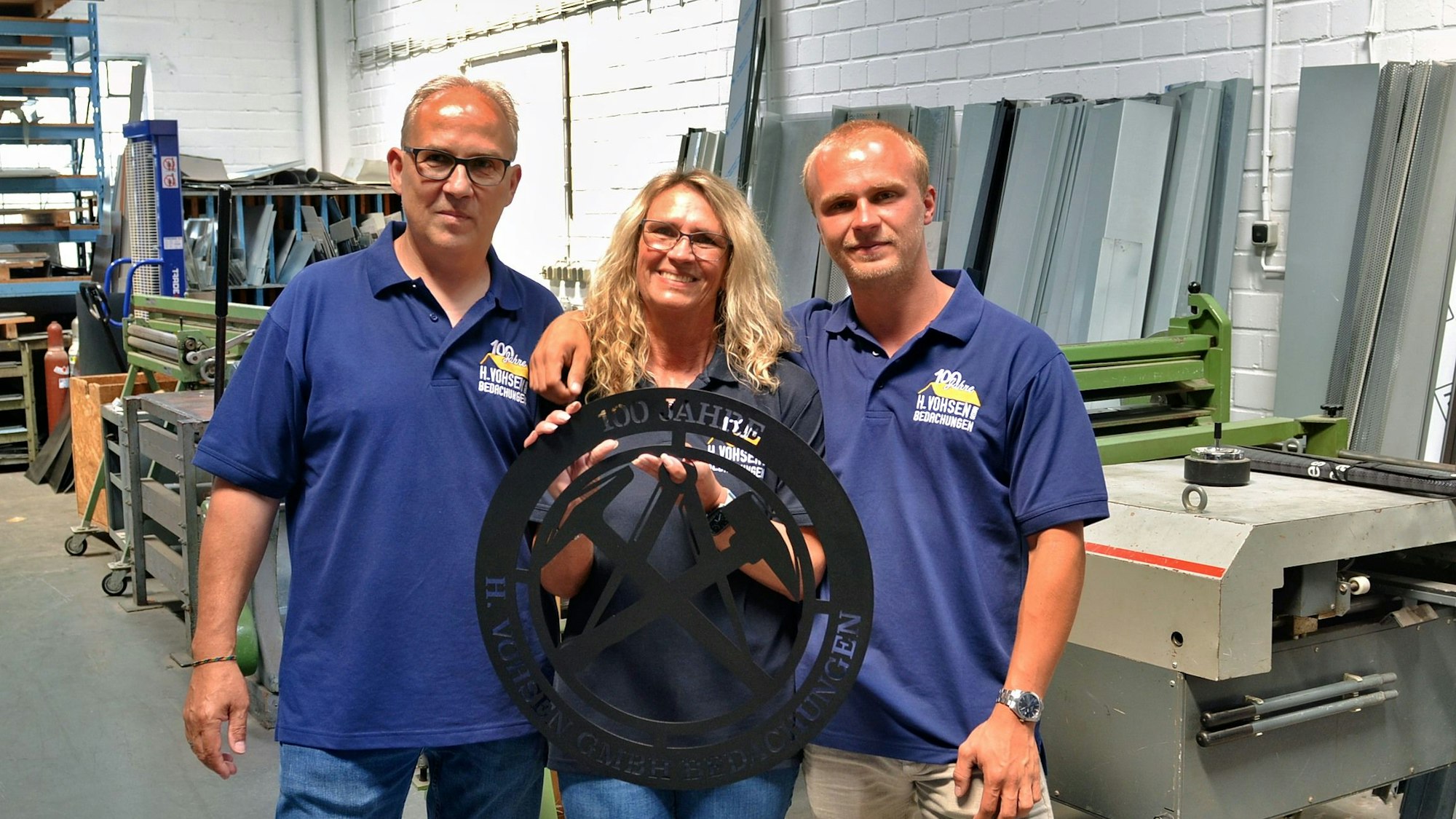 Dirk, Ruth und Marcel Schindler posieren in der Werkstatt für ein Foto.