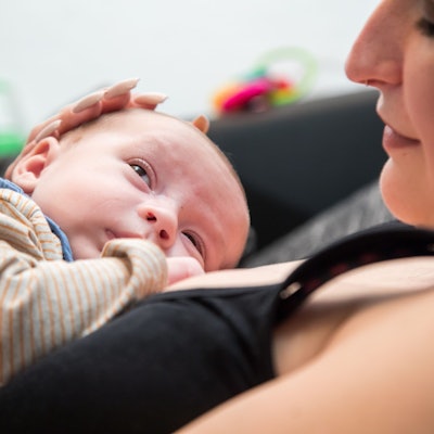 Ein Säugling liegt auf der Brust seiner Mutter.