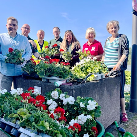 Die Blumenkübel am Rheinufer haben Vertreterinnen und Vertreter von Porzer Schützenvereinen zusammen mit dem Bürgerverein Porz-Mitte bepflanzt.