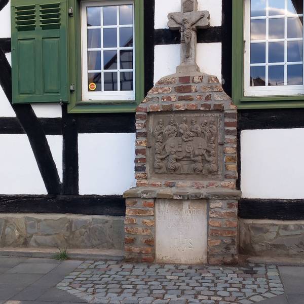 Ein Kreuz am Obsthof Rönn in Ersdorf mit Abendmahlszene