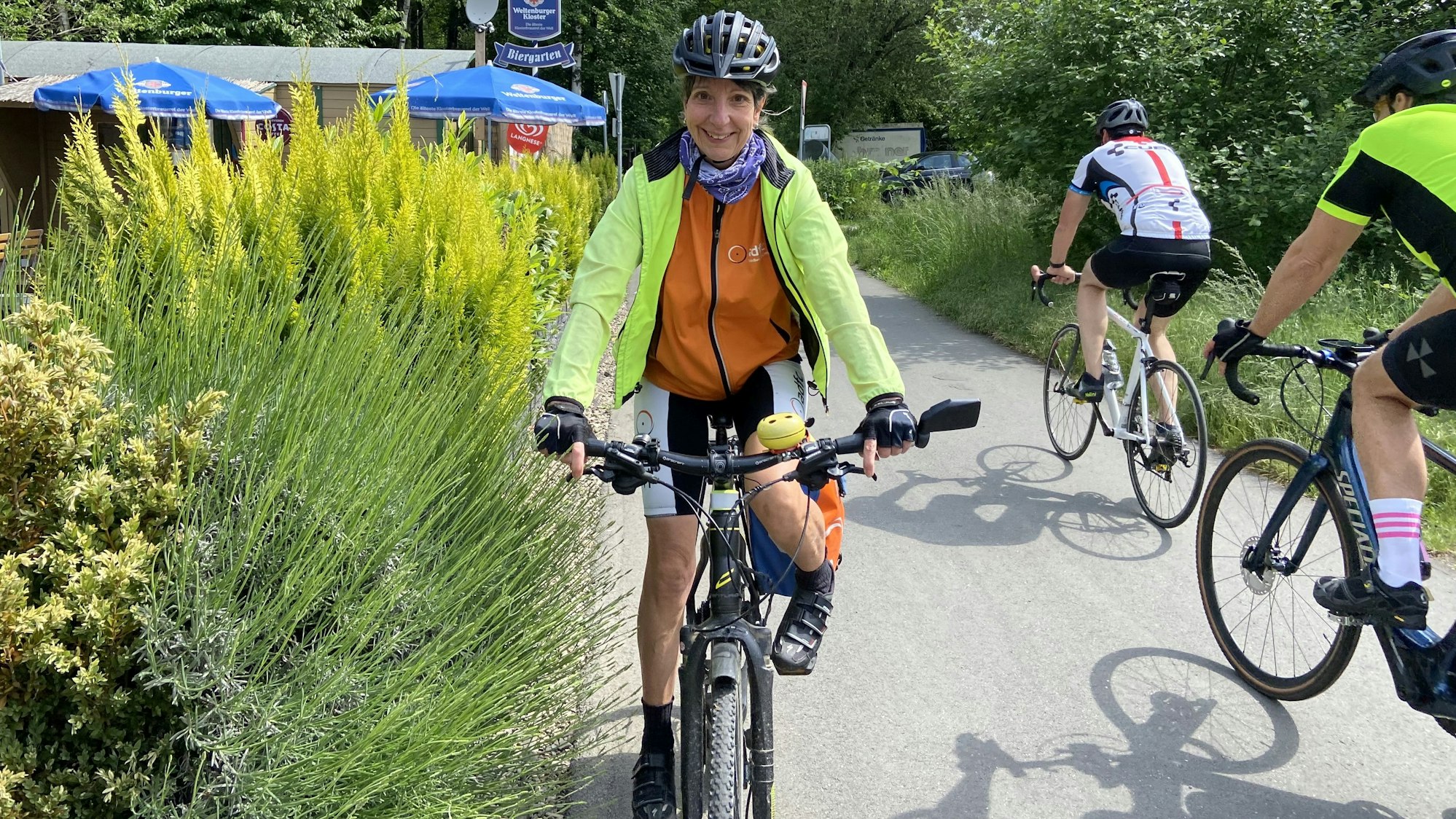 Eine Frau fährt auf einem Fahrrad einen Radweg entlang.