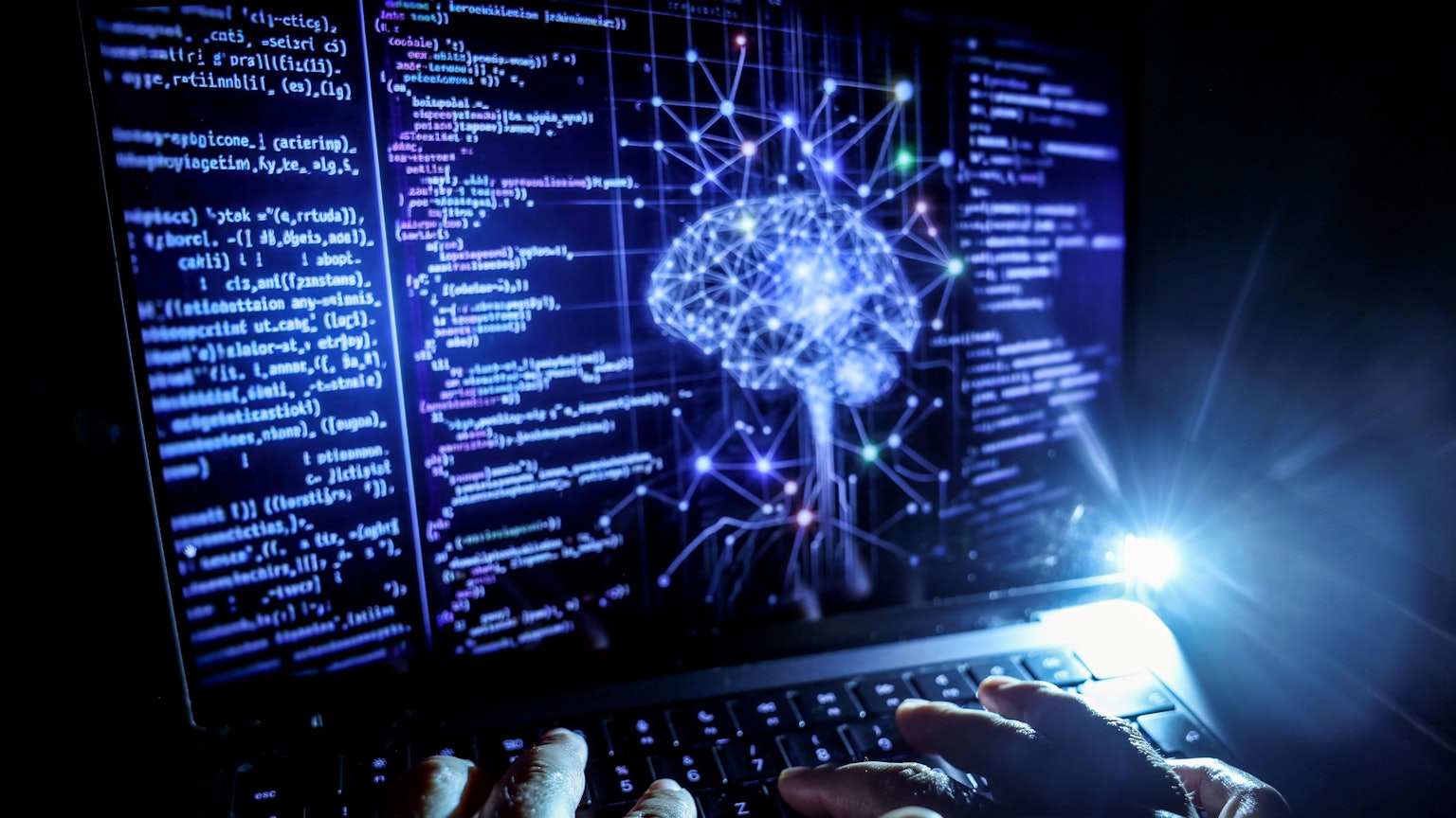 Nordrhein-Westfalen, Köln: Eine Person arbeitet am Rechner, auf dessen Bildschirm ein durch Künstliche Intelligenz generiertes Illustrationsbild mit Code verschiedener Programmiersprachen und einem neuronalen Netzwerk-Diagramm zu sehen ist. (Symbolbild)