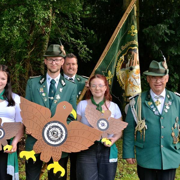 Die Nemmenicher Schützen psieren in Uniformen und halten Vögel und Fahne.