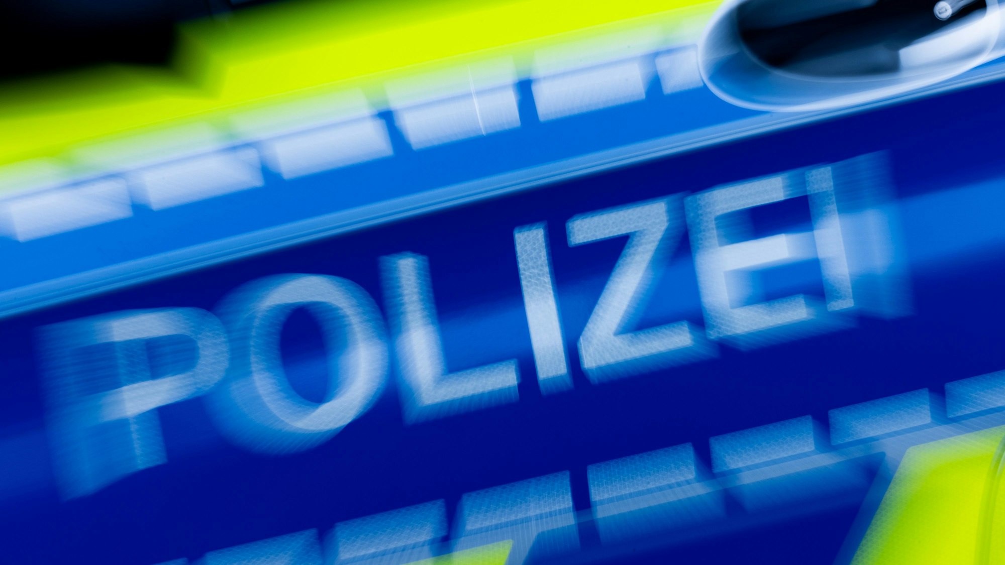 Das Bild zeigt den Schriftzug Polizei auf der Autotüre eines Streifenwagens.
