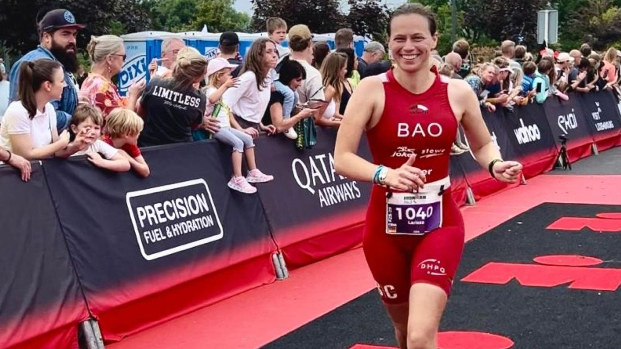 Bild einer Triathletin, die ins Ziel läuft.