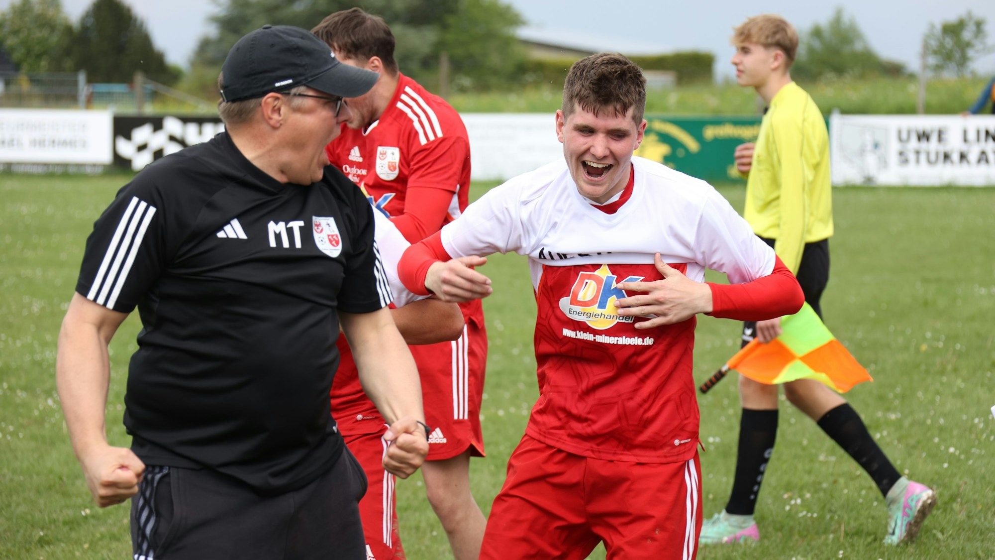 Das Bild zeigt Marcel Timm, der seine Freude herausschreit. Spieler Haep zieht sein Aufstiegs-T-Shirt an.