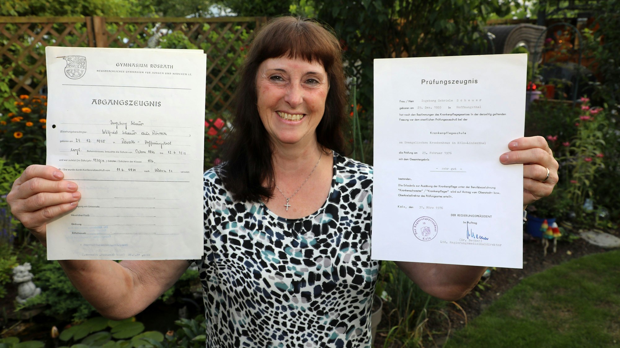 DRK-Kreisvorsitzende Ingeborg Schmidt aus Rösrath hält zwei Zeugnisse in den Händen.