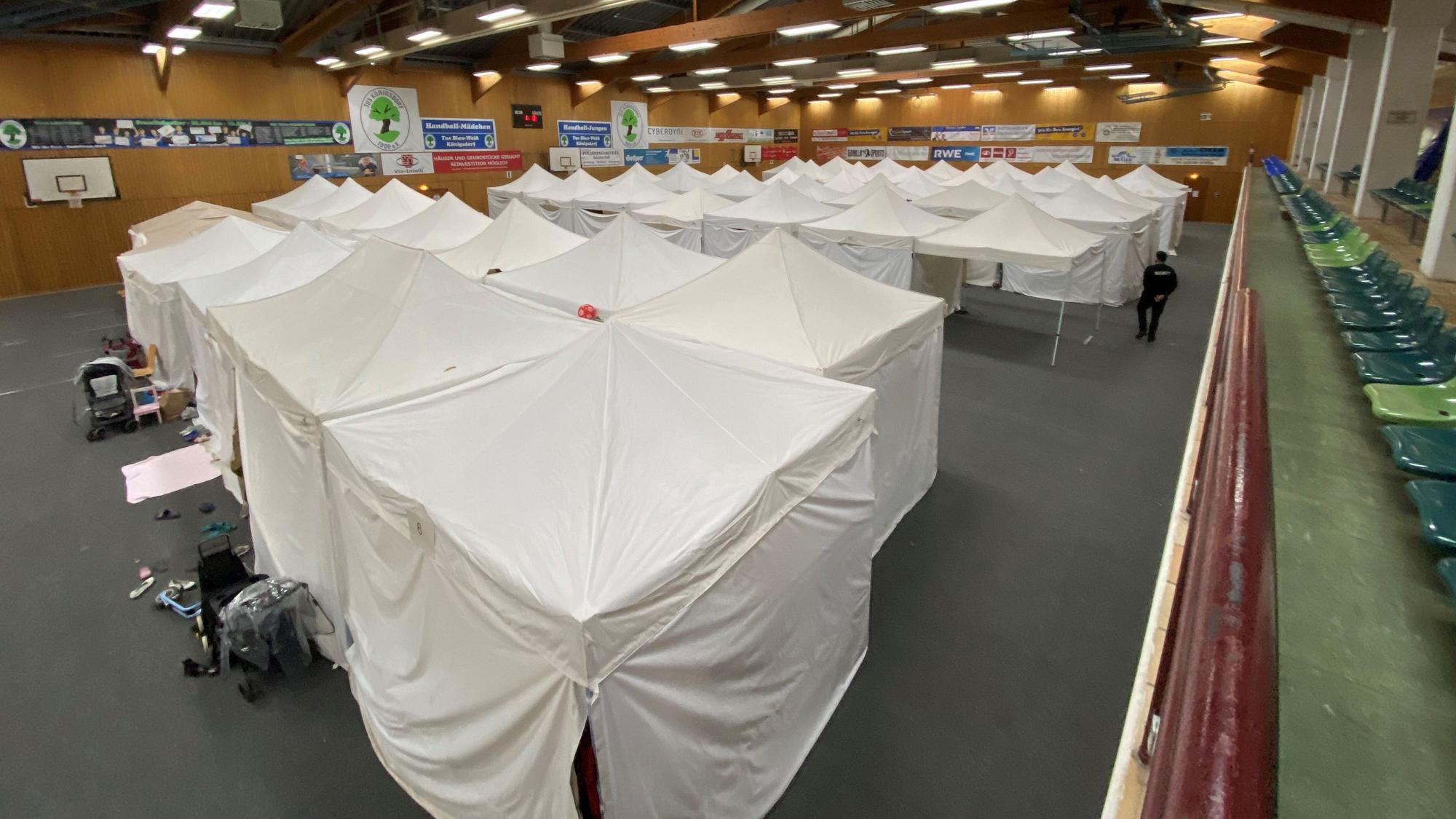 Auf dem Bild ist eine Zeltstadt in einer Turnhalle zu sehen.