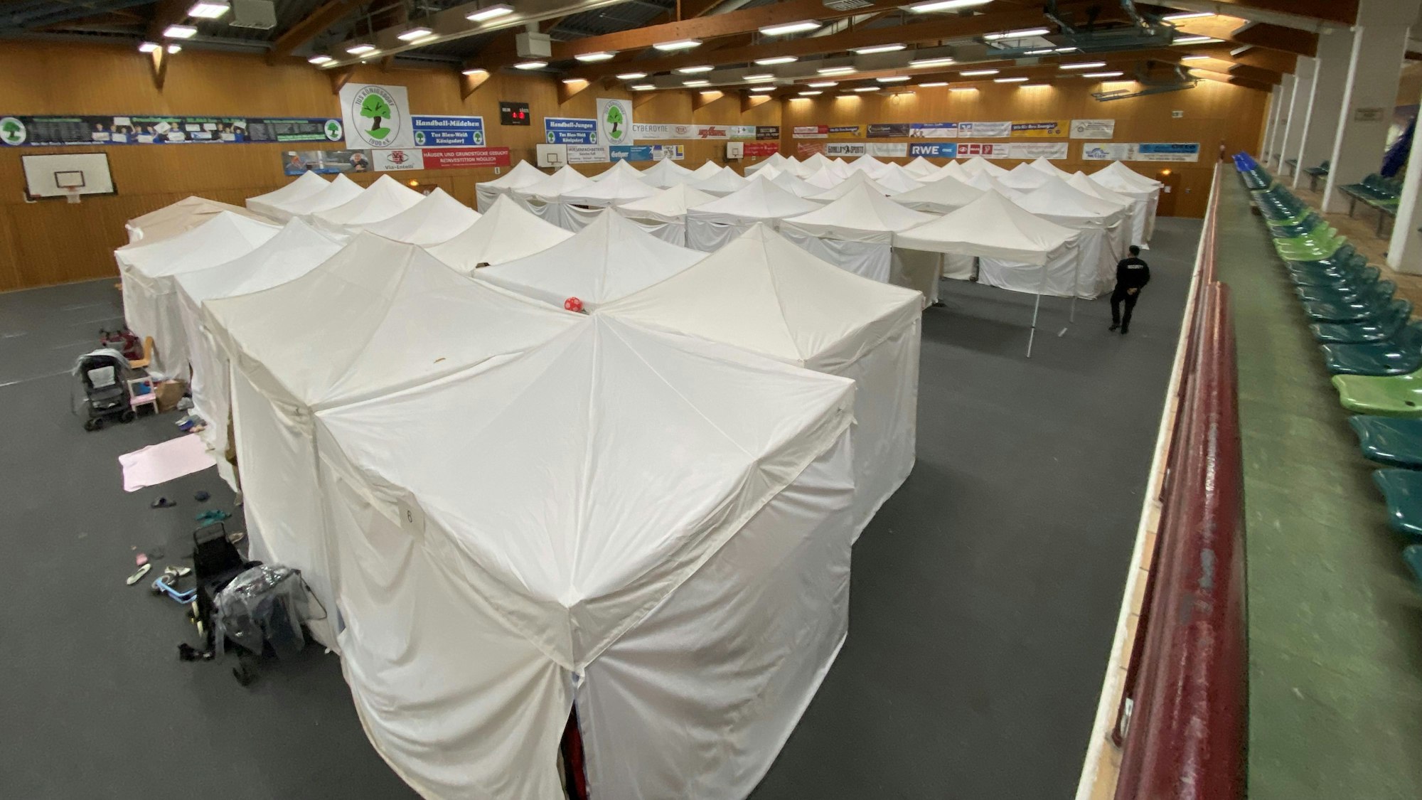 Auf dem Bild sind weiße Partyzelte in einer Turnhalle zu sehen.