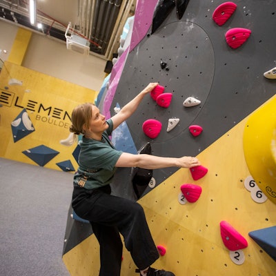 Eine Frau hängt an der Kletterwand