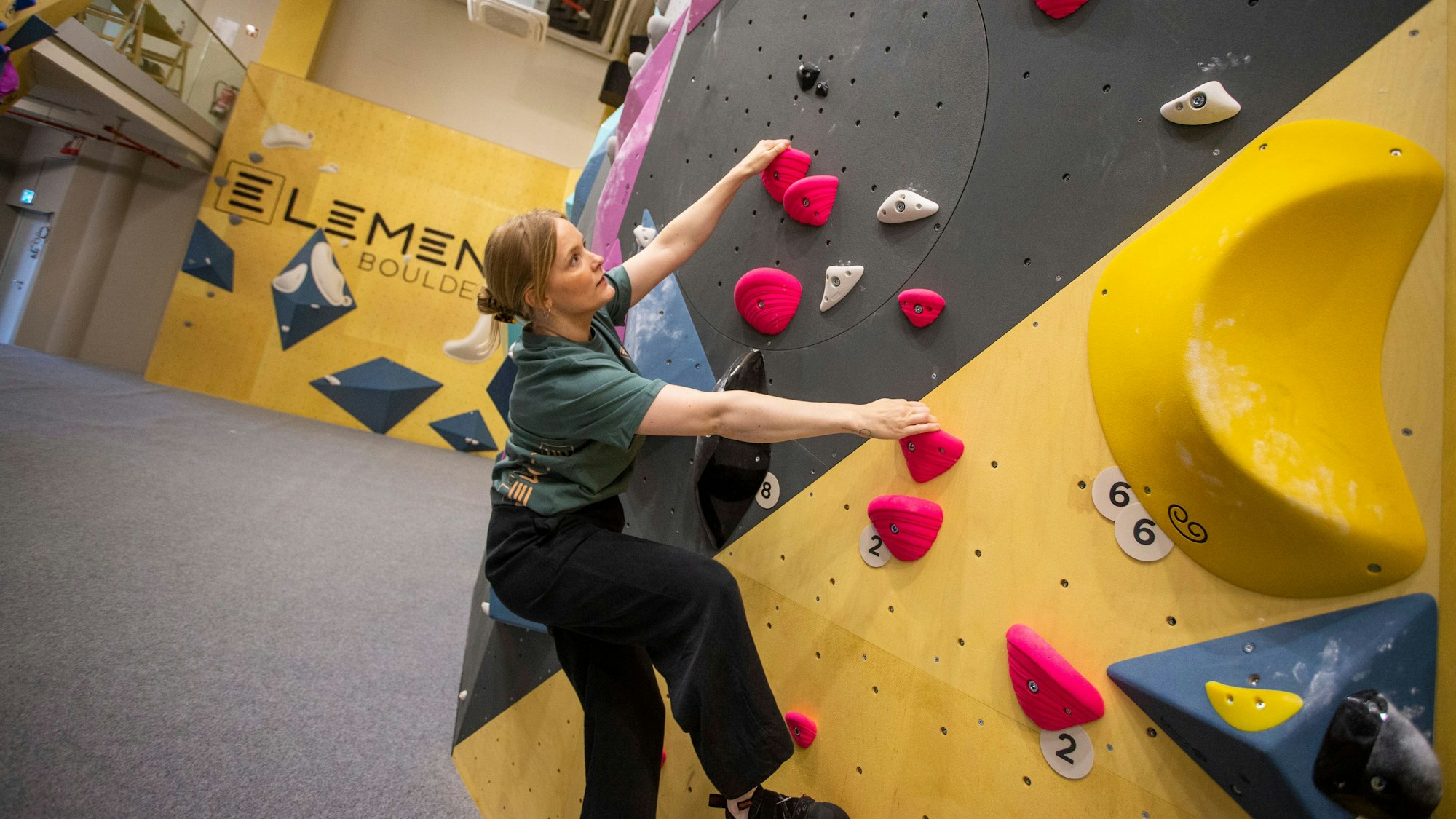Eine Frau hängt an der Kletterwand