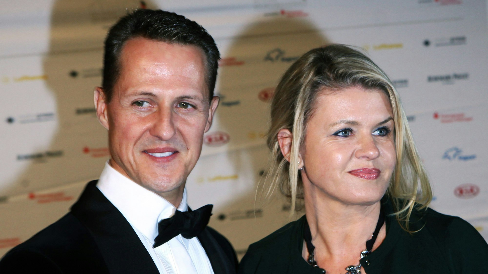 Formel-1-Rennfahrer Michael Schumacher und seine Frau Corinna lachen in die Kameras.