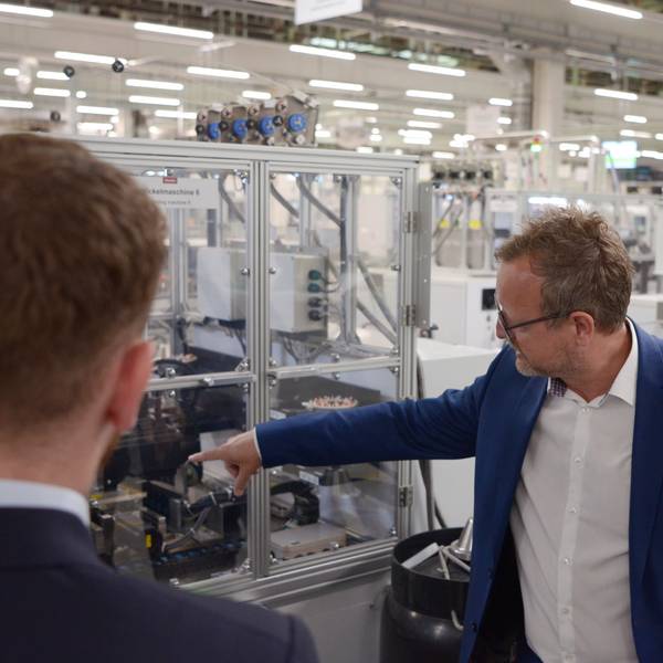 Jürgen Zdunek deutet auf eine Produktionsanlage.