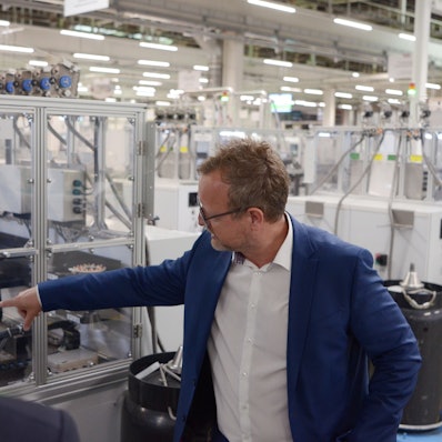 Jürgen Zdunek deutet auf eine Produktionsanlage.