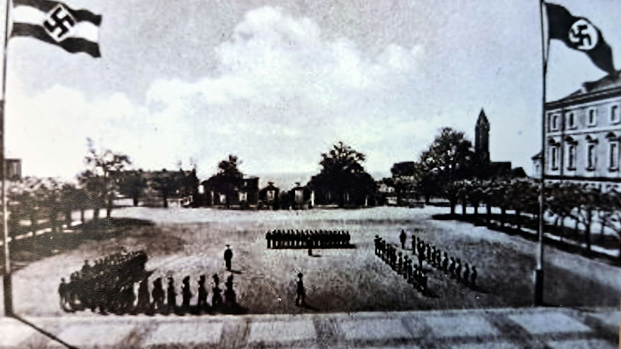 Auf dem historischen Foto vom Schlosshof marschieren Soldaten, rechts und links wehen Nazi-Flaggen.