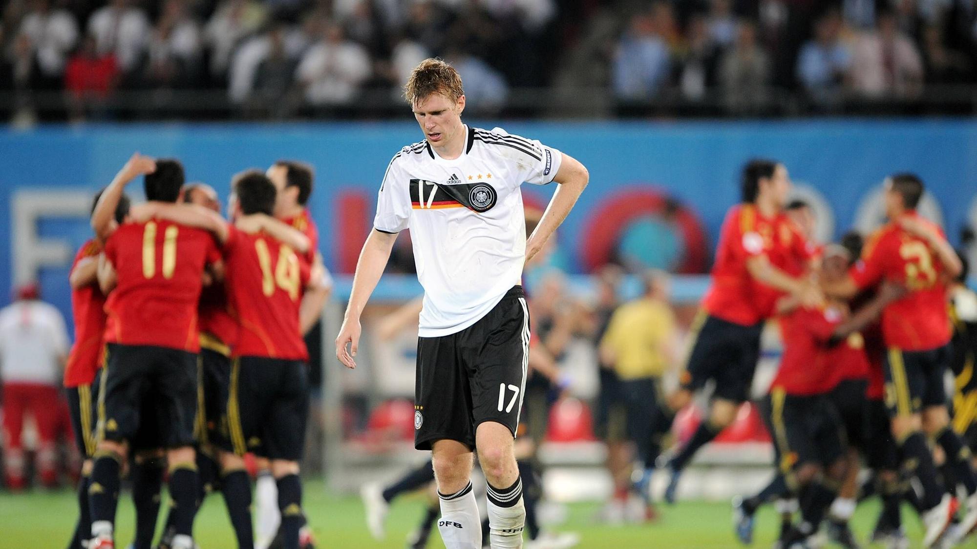 Per Mertesacker steht enttäuscht vor jubelnden Spaniern nach dem EM-Finale 2008.