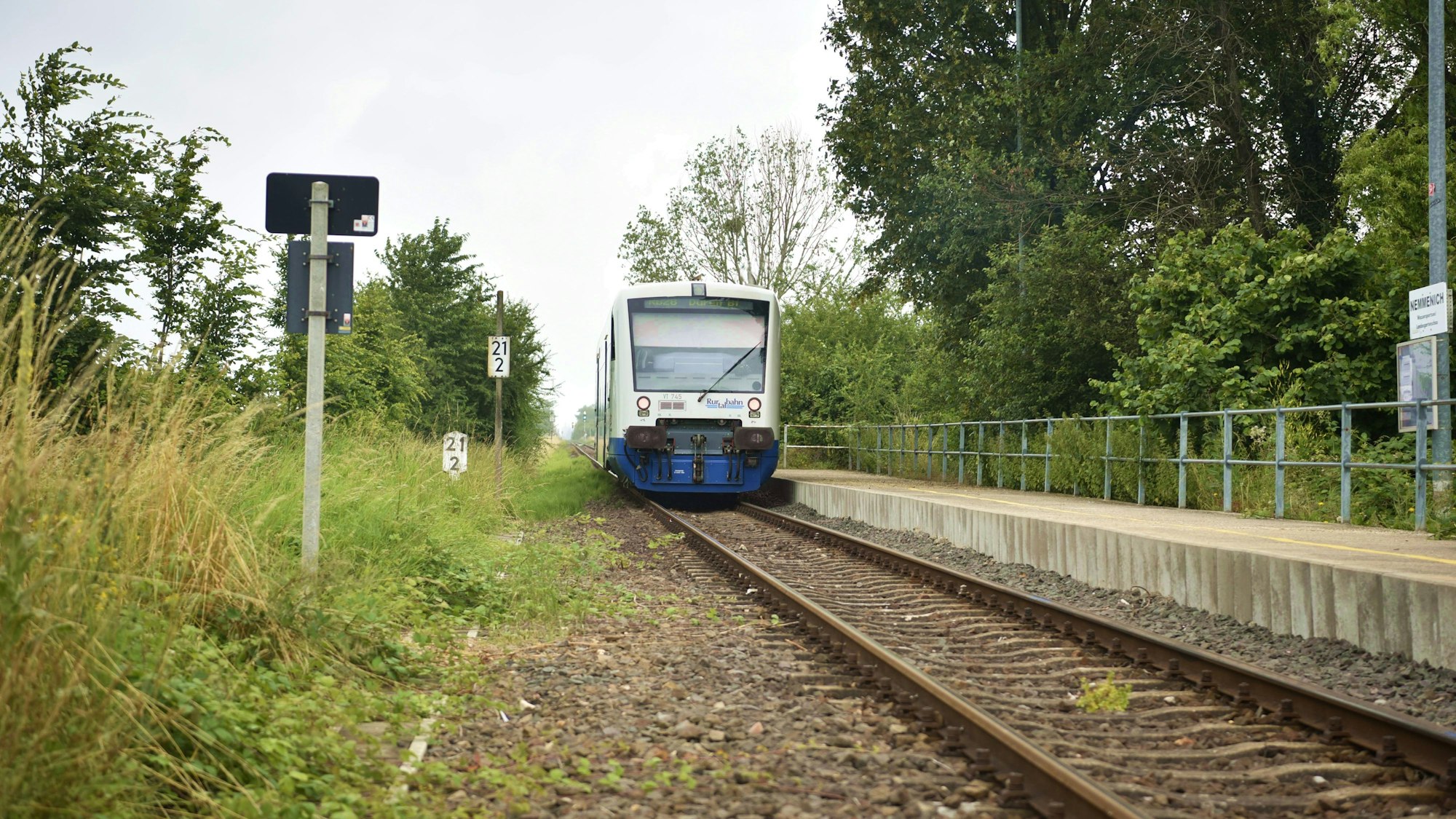 Ein Zug der Rurtalbahn fährt am Bahnsteig Nemmenich ab.