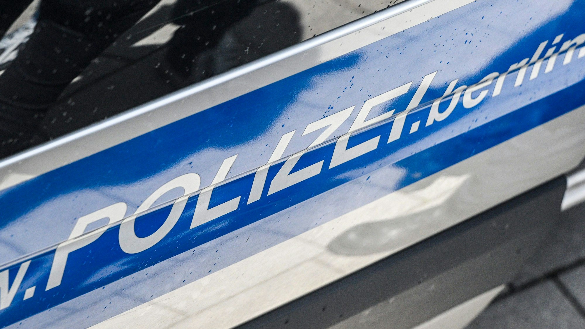 Der Schriftzug „Polizei“ auf einer Autotür eines Streifenwagens.
