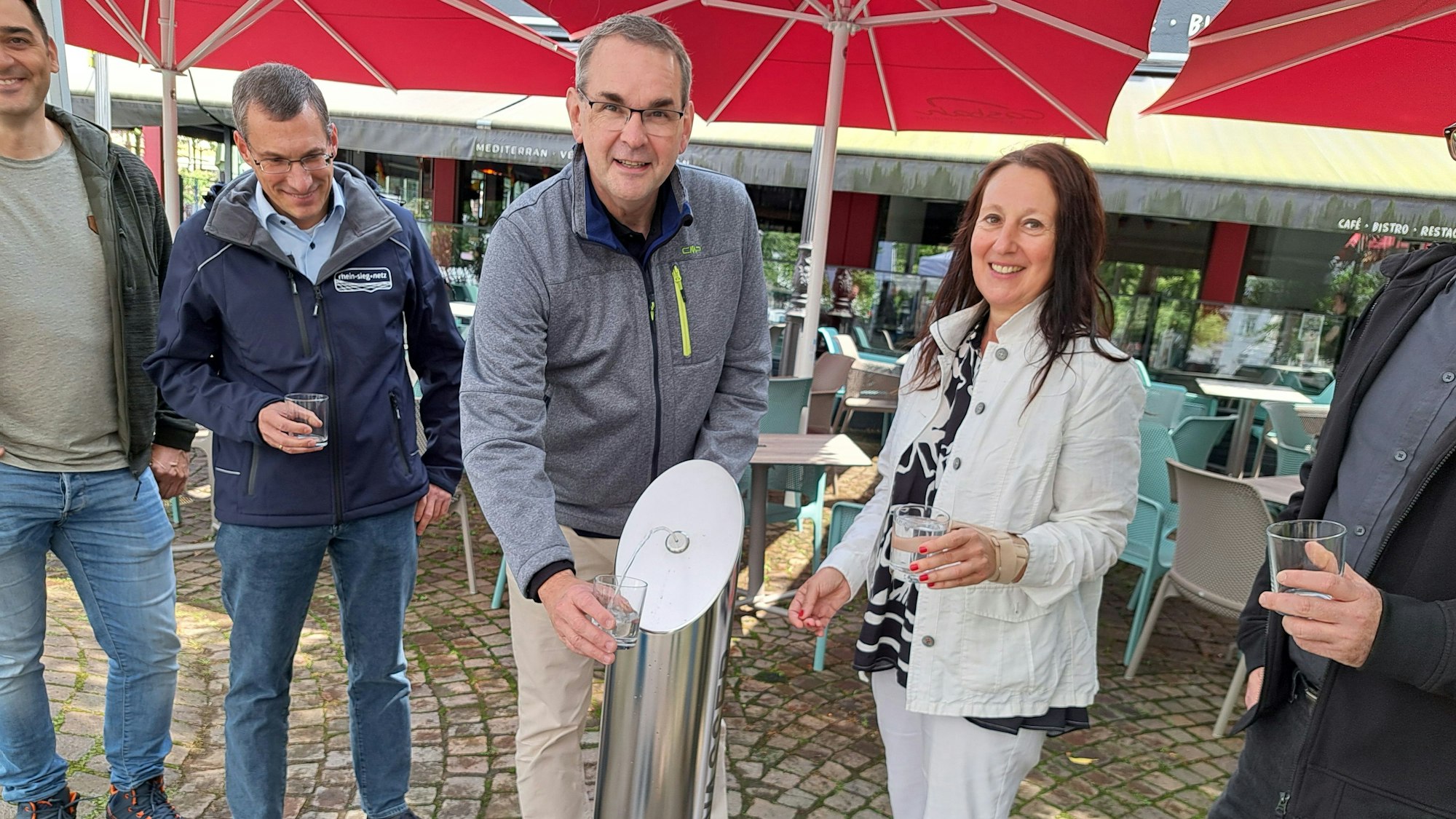 Auf dem Hühnermarkt in der Siegburger City gibt es jetzt einen öffentlichen Trinkwasserbrunnen. Bürgermeister Stefan Rosemann und Ideengeberin Melanie Fabricius haben ihn in Betrieb genommen.