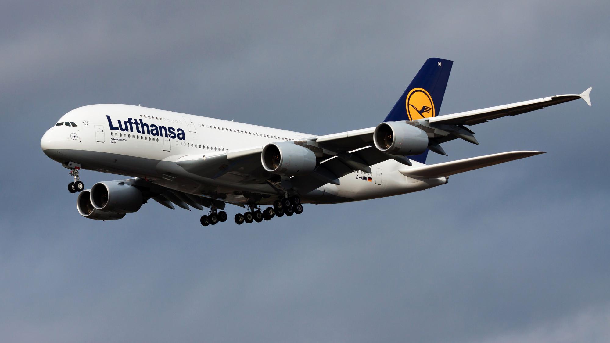 Ein Airbus A380 der deutschen Fluggesellschaft Lufthansa im Landeanflug vor einem bewölkten Himmel.