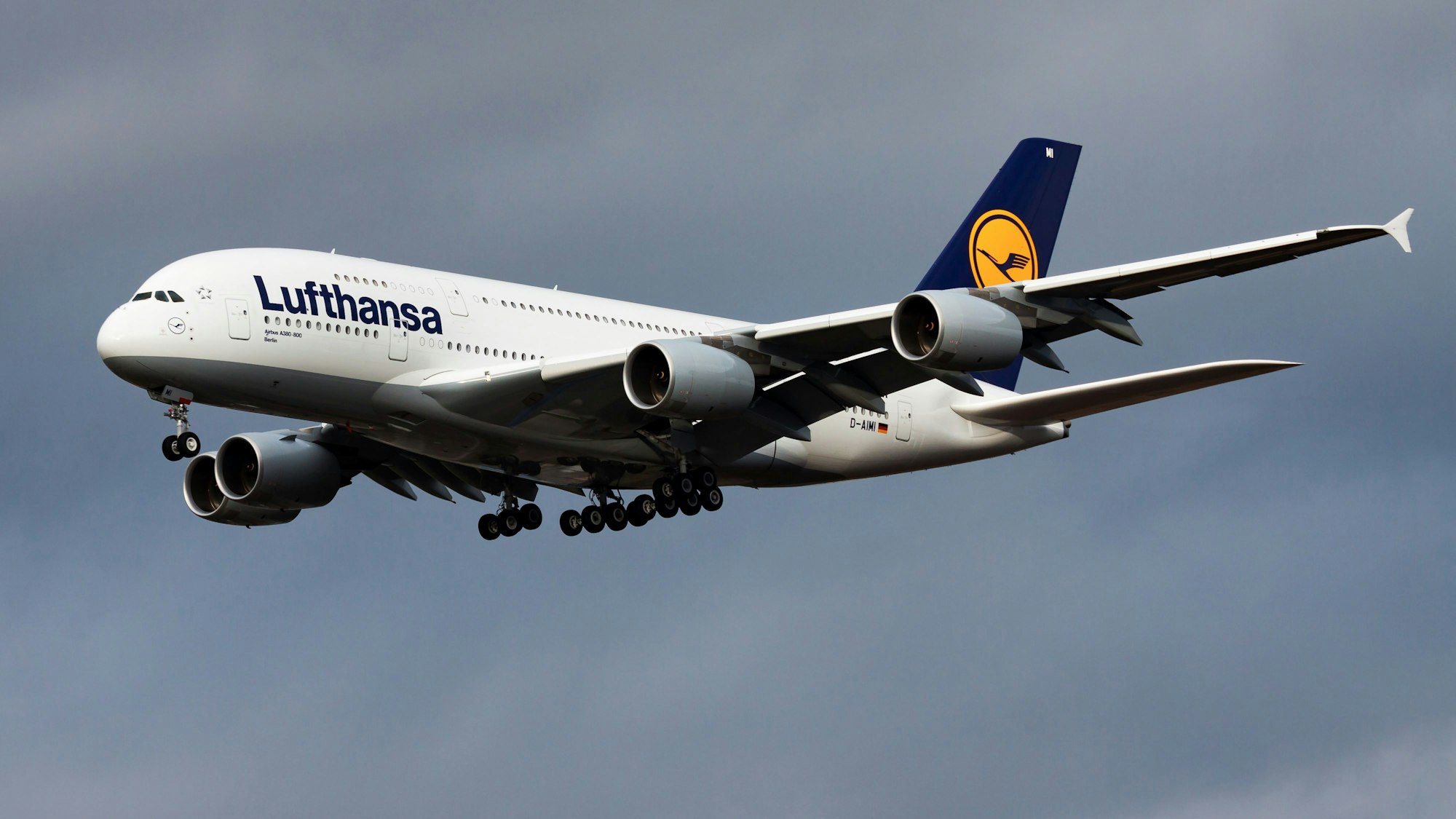 Ein Airbus A380 der deutschen Fluggesellschaft Lufthansa im Landeanflug vor einem bewölkten Himmel.