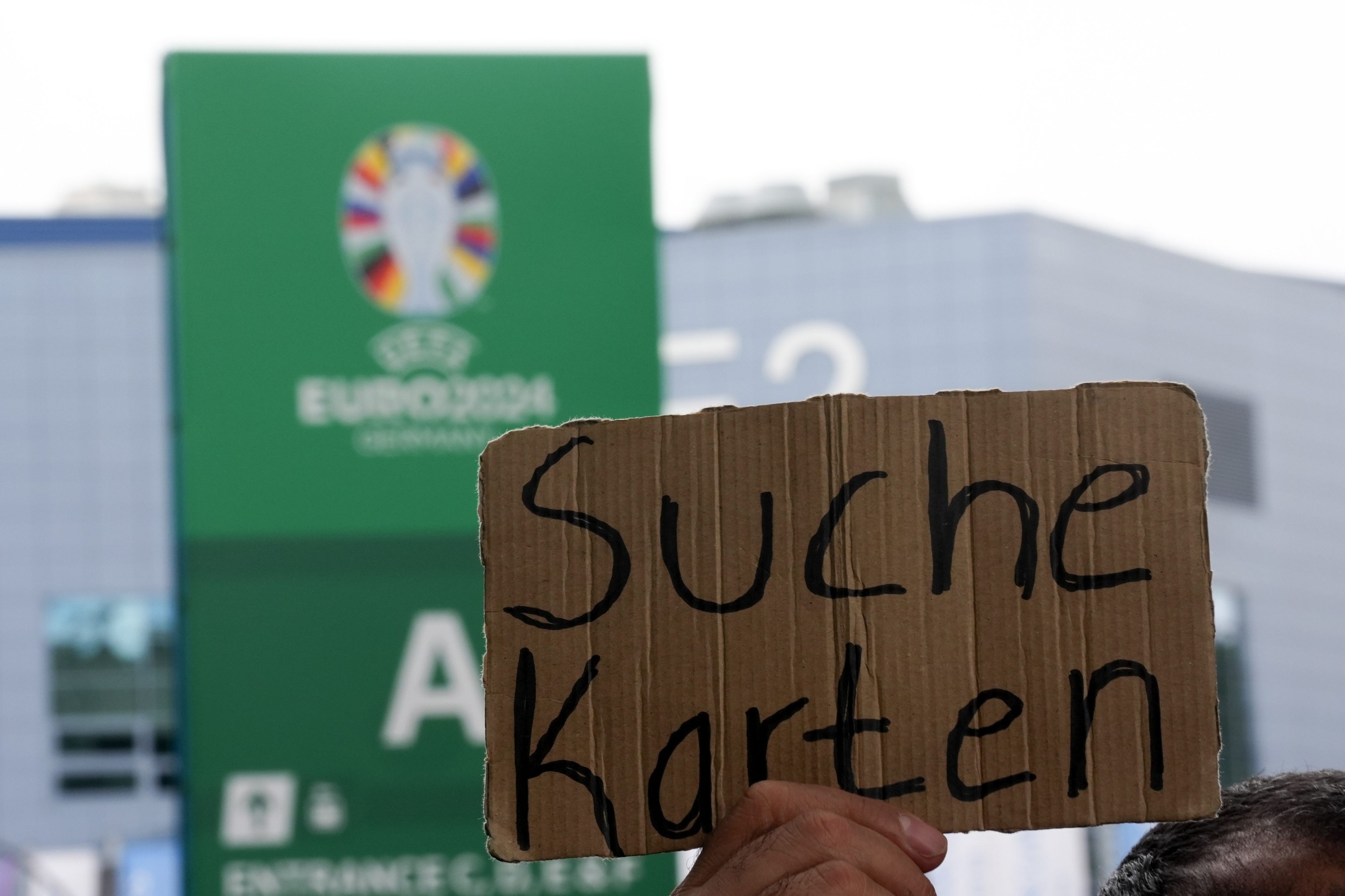 Ein Schild mit der Aufschrift „Suche Karten“ wird hochgehalten.