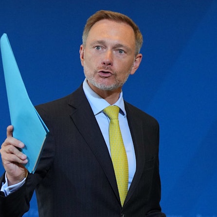Christian Lindner (FDP), Bundesminister der Finanzen, winkt mit einem blauen Hefter. (Archivbild)
