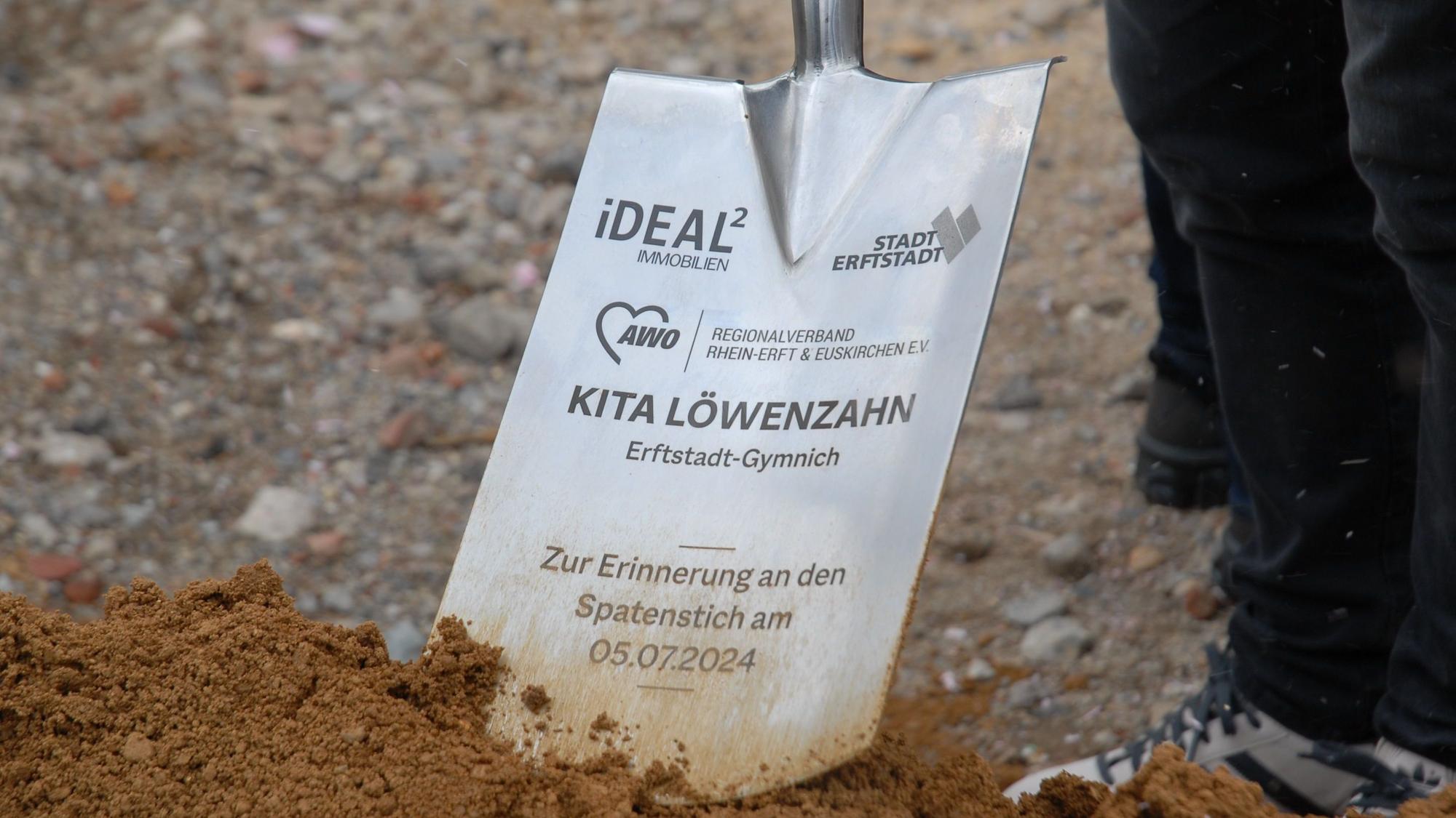 Zu sehen ist eine metallene Schaufel mit Beschriftung.