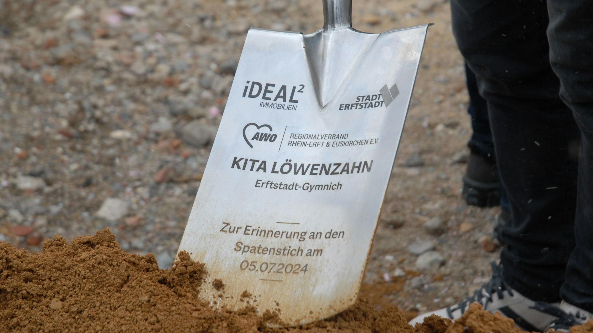 Zu sehen ist eine metallene Schaufel mit Beschriftung.