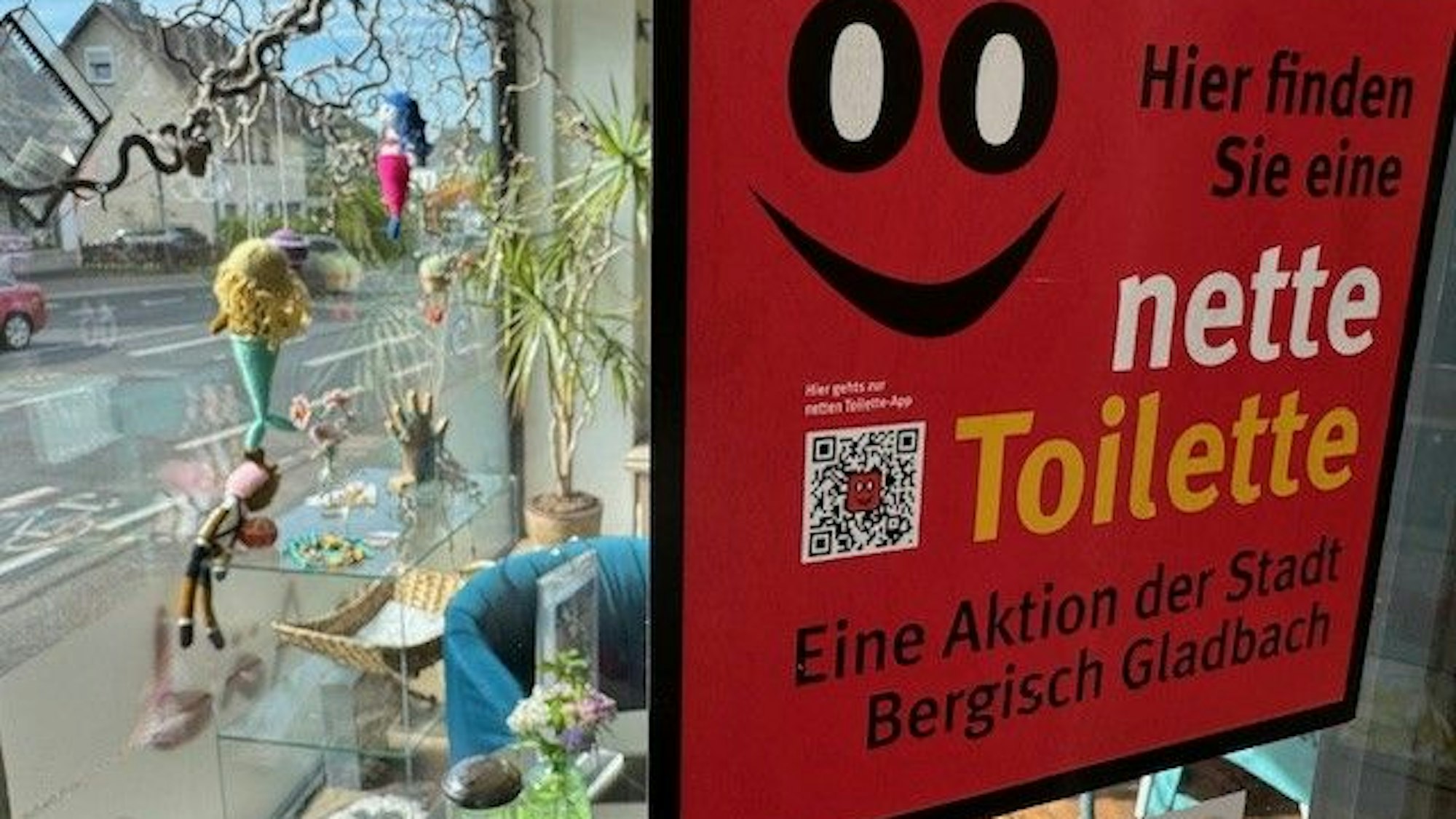 Zu sehen ist das rote Logo der Netten Toilette, das in einem Schaufenster steht.