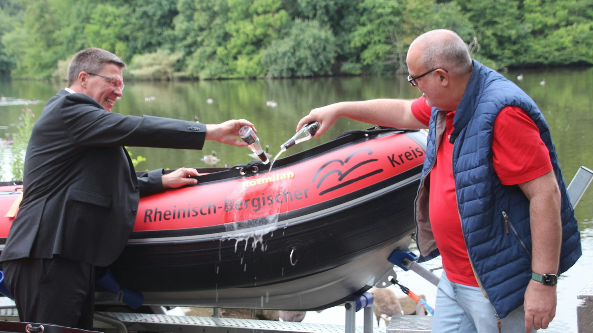 Landrat Stephan Santelmann (l.) und Ausschuss-Vorsitzender Ulrich Heutz taufen das Boot „Rotmilan“ auf seinen neuen Namen.