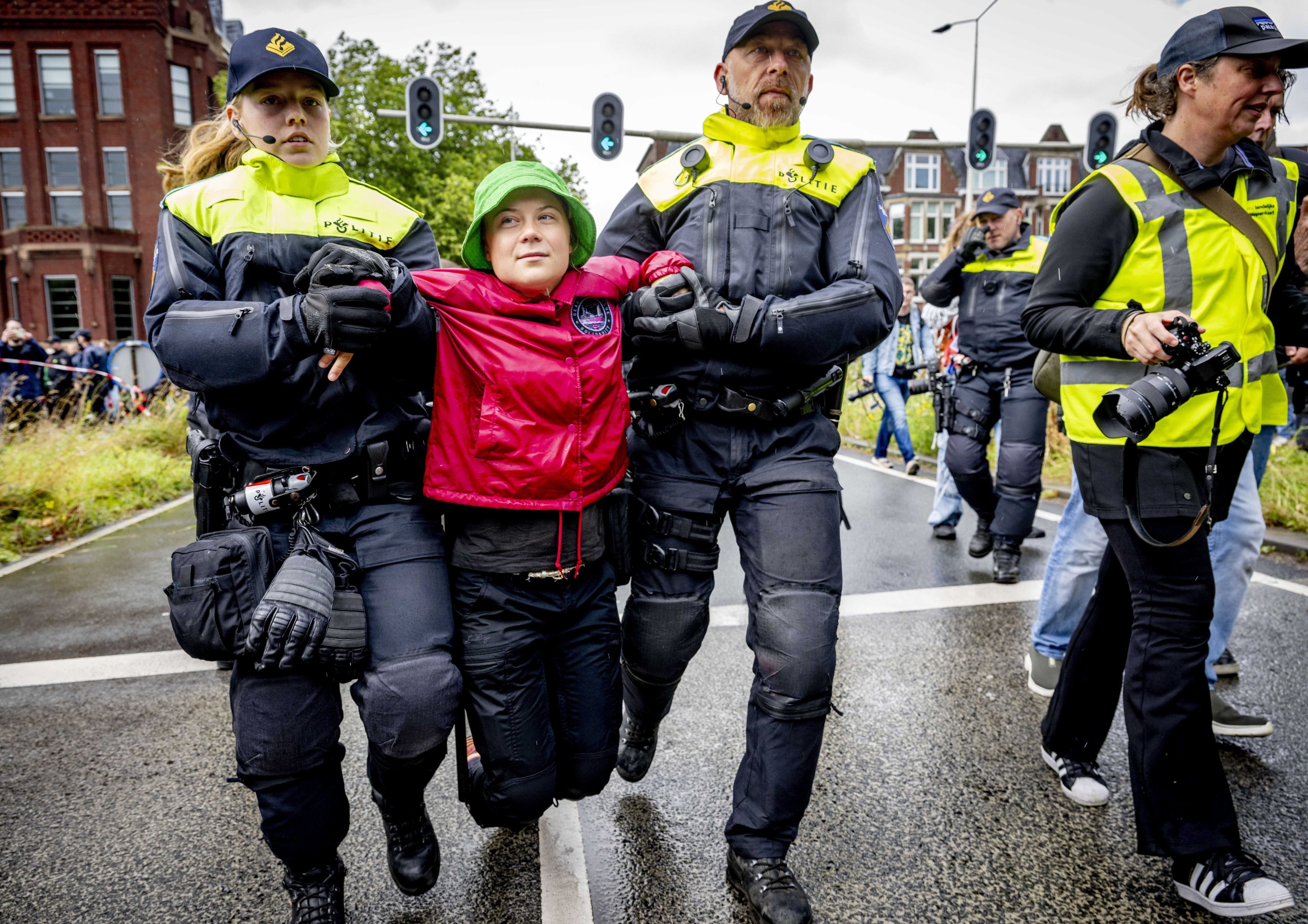 Niederlande, Den Haag: Klimaaktivistin Greta Thunberg (M) wird bei einer Demonstration der Umweltinitiative Extinction Rebellion (XR), die eine Auffahrt zur Autobahn A12 blockiert, von Polizeibeamten abgeführt.