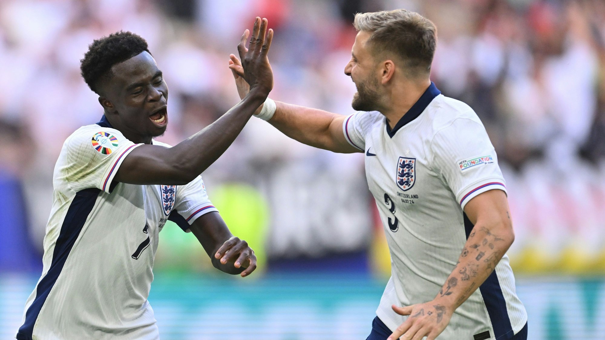 Fußball, UEFA Euro 2024, EM, England - Schweiz, Finalrunde, Viertelfinale, Düsseldorf Arena, Englands Bukayo Saka jubelt mit Luke Shaw (r) über sein Tor zum 1:1.