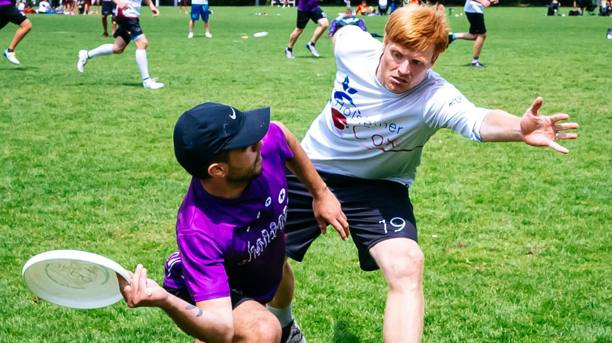 Ein Spieler versucht beim Ultimate Frisbee einen anderen zu blocken.